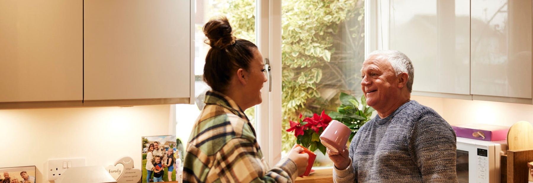 Family members talking and having a cup of tea in the kitchen