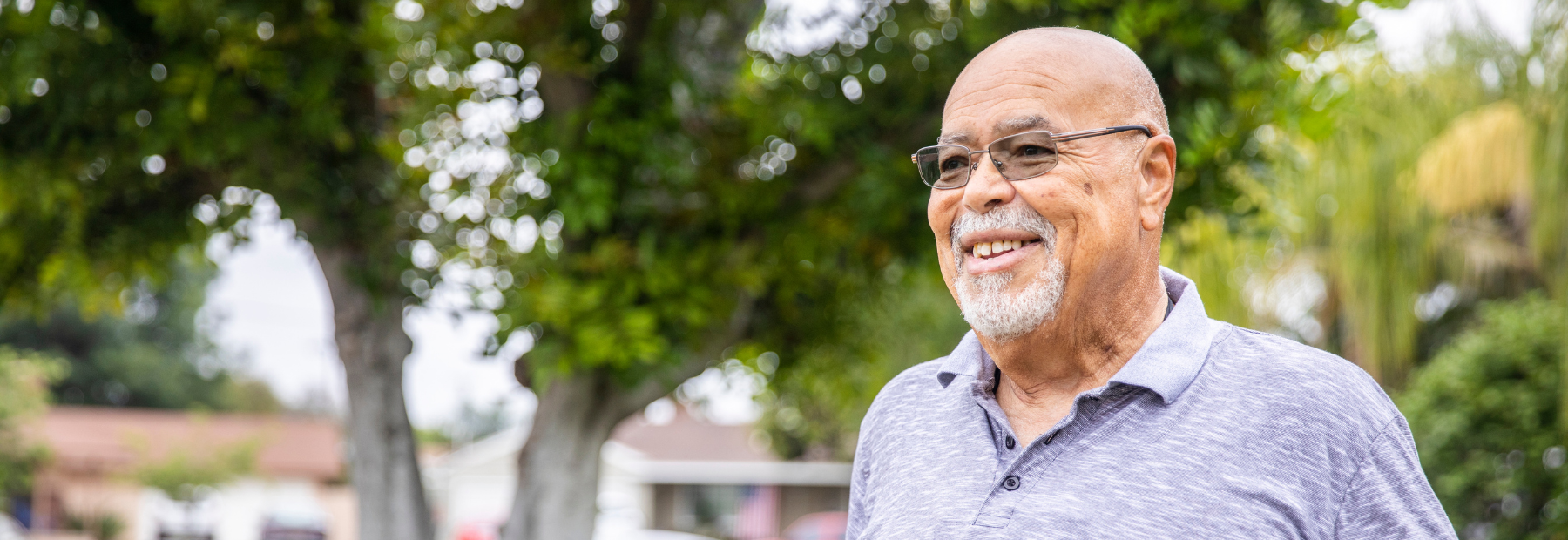 Male member outside home, trees in background