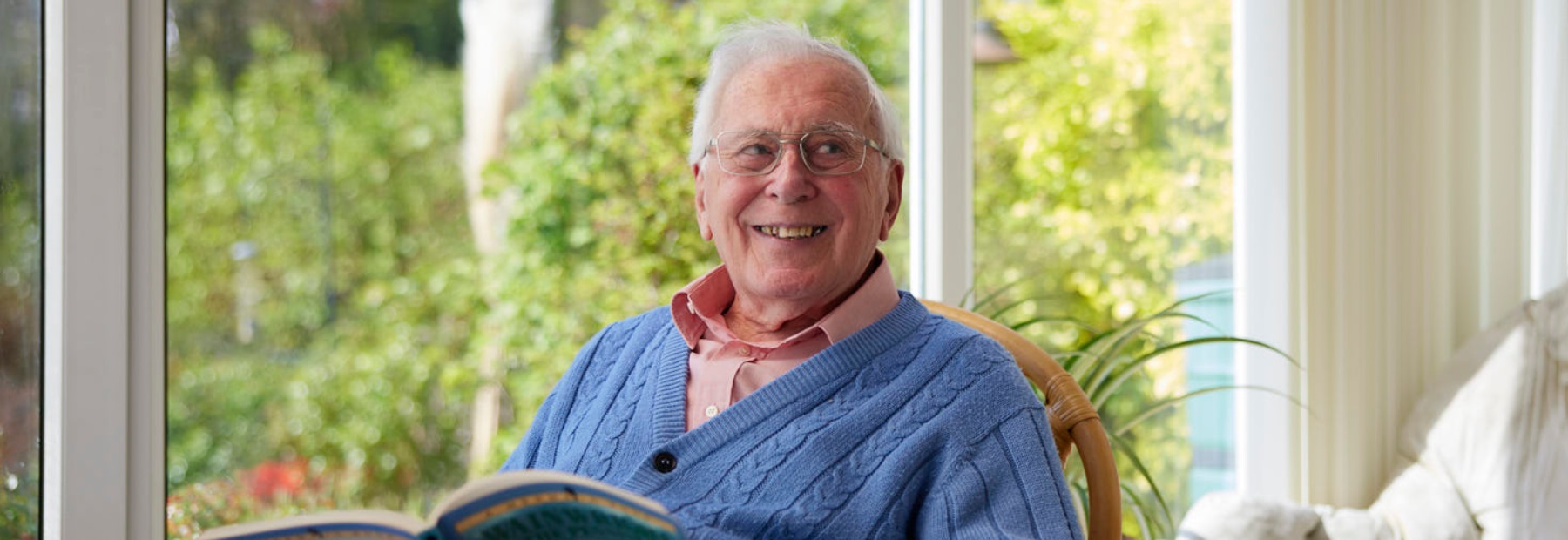 Man smiling and holding a book