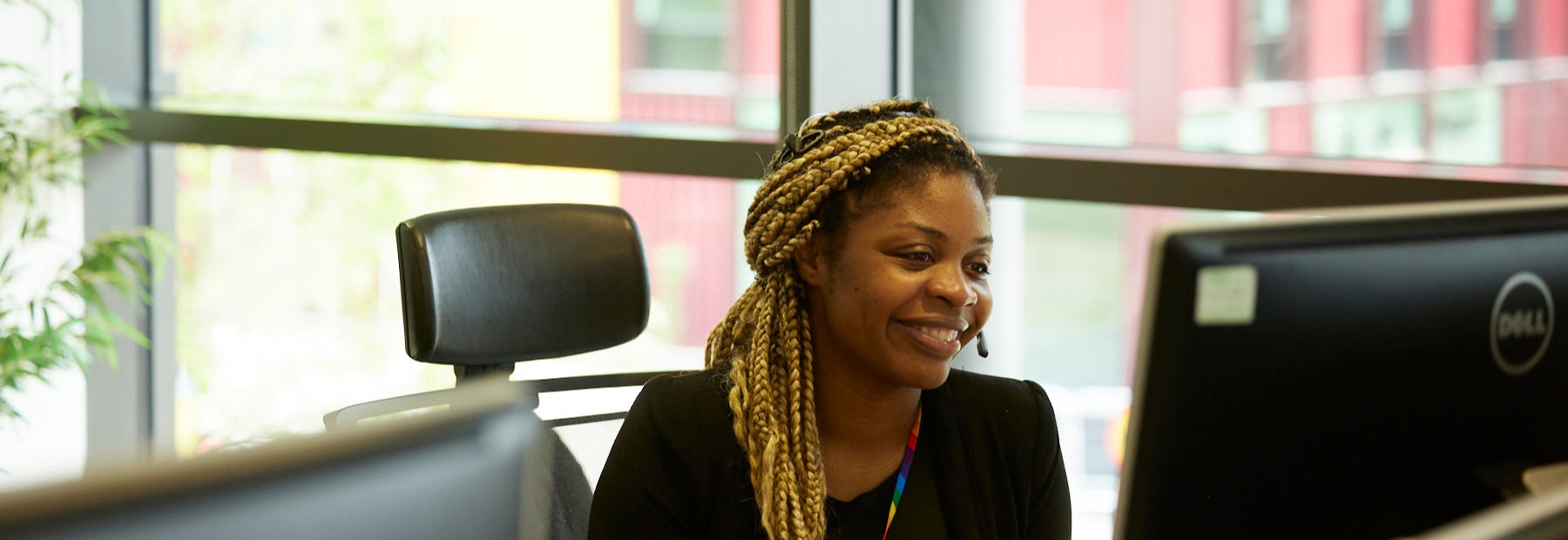Female colleague at desk with headset smiling