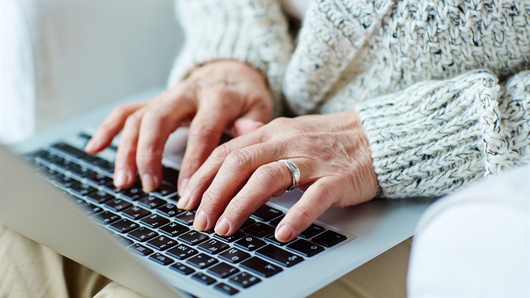 Person typing on laptop keyboard