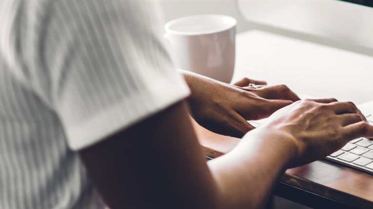 woman typing on computer keyboard